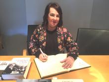 La presidenta del Parlamento firmando en el libro de honor de la casa Ramón y Cajal.