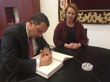 El embajador Avet Adonts firmando en el libro de honor del Parlamento.