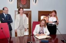 La Ministra firma en el libro de honor del Ayuntamiento.