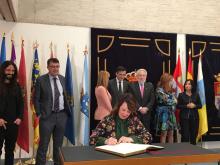 La presidenta del Parlamento de Navarra firmando en el libro de autoridades de las Cortes de Castilla y León